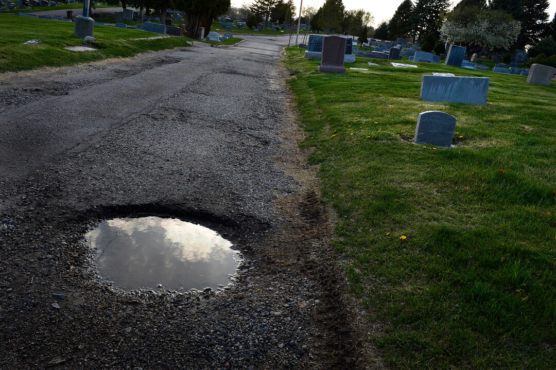 (Scott Sommerdorf | The Salt Lake Tribune)This pothole marred road is not unusual inside the Salt Lake City Cemetery, Friday, April 13, 2018. The cemetery is historic, beloved by relatives, neighbors, nature and recreation lovers -- and needs about $27 million in repairs, improvements and financial aid. The city is reviewing a master plan to make fixes and improvements. 