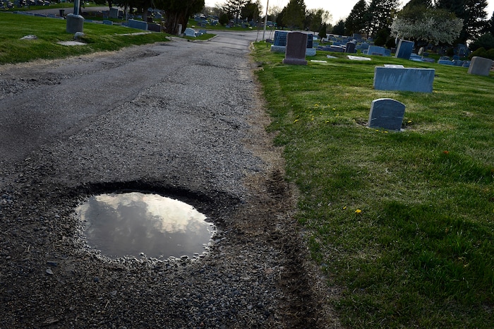(Scott Sommerdorf | The Salt Lake Tribune)
This pothole marred road is not unusual inside the Salt Lake City Cemetery, Friday, April 13, 2018. The cemetery is historic, beloved by relatives, neighbors, nature and recreation lovers -- and needs about $27 million in repairs, improvements and financial aid. The city is reviewing a master plan to make fixes and improvements. 
