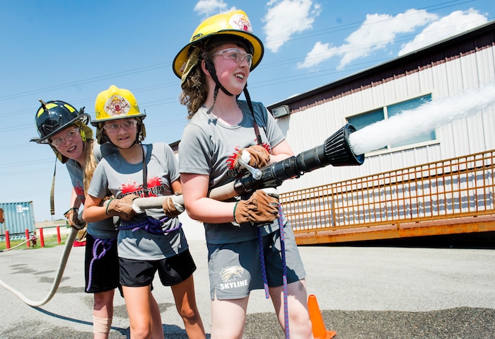 (Rick Egan  |  The Salt Lake Tribune)  Liz Nicole and Annika spray water from a firehoses while competing in a fire fighter skills relay, while attending Camp Fury.  A dozen Utah Girl Scouts participated in a 3-day camp led by female firefighters. Camp Fury Utah was developed in partnership with the Girl Scouts and local fire and police departments, designed to expose teen girls to careers in public safety and other non-traditional jobs. Saturday, August 5, 2017.


