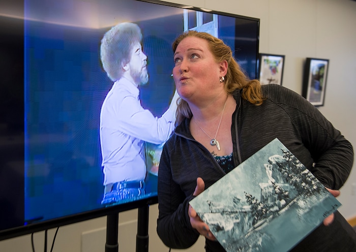 (Leah Hogsten  |  The Salt Lake Tribune) Christine McDonough leans in to blow a kiss at former television star painter, the late Bob Ross, after a Bob Ross Paint-Along class, Saturday, Jan. 6, 2018, at the Salt Lake City Public Library's Sweet Branch in the Avenues.