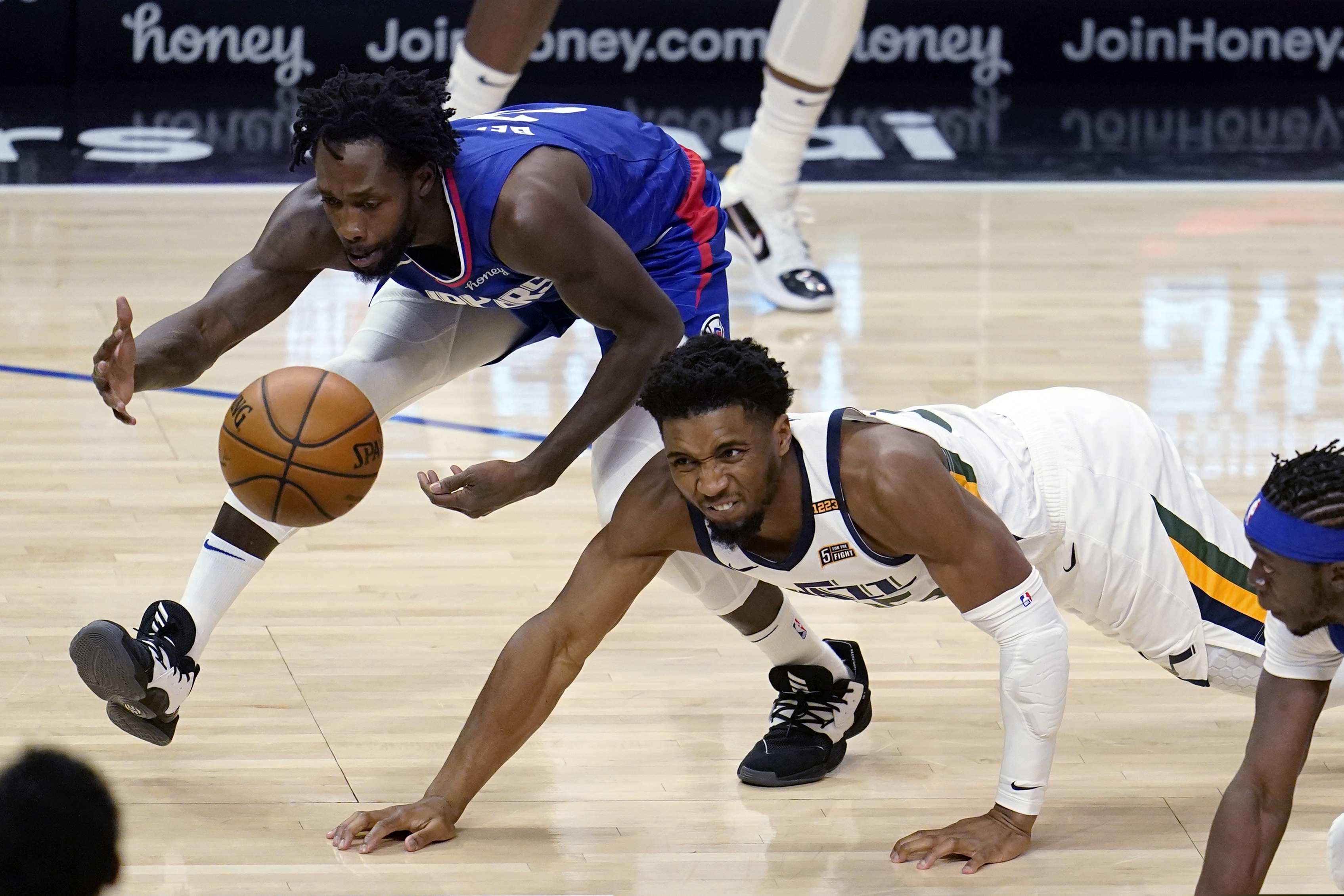 Utah Jazz guard Donovan Mitchell, right, vies for a loose ball against Los Angeles Clippers guard Patrick Beverley during the first half of an NBA basketball game Wednesday, Feb. 17, 2021, in Los Angeles. (AP Photo/Marcio Jose Sanchez)