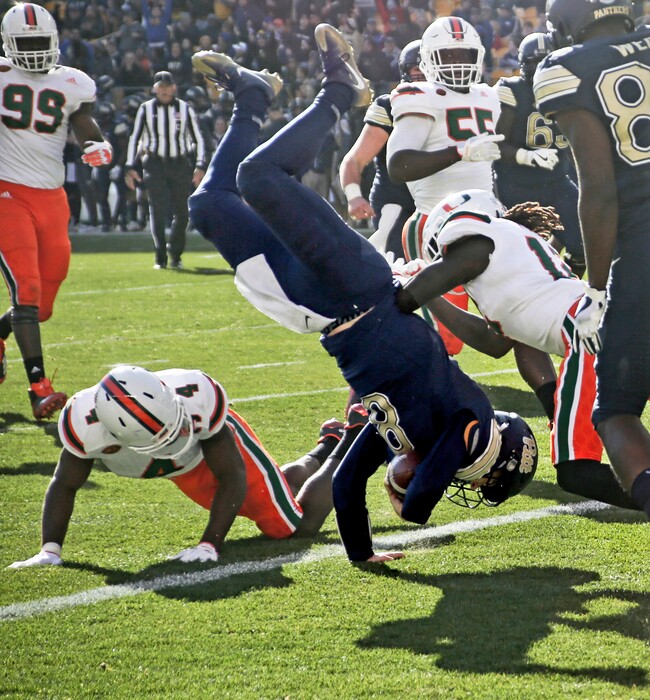 Pittsburgh quarterback Kenny Pickett (8) flips over Miami defensive back Jaquan Johnson (4) as he goes in for a touchdown in the first half of an NCAA college football game, Friday, Nov. 24, 2017, in Pittsburgh. (AP Photo/Keith Srakocic)