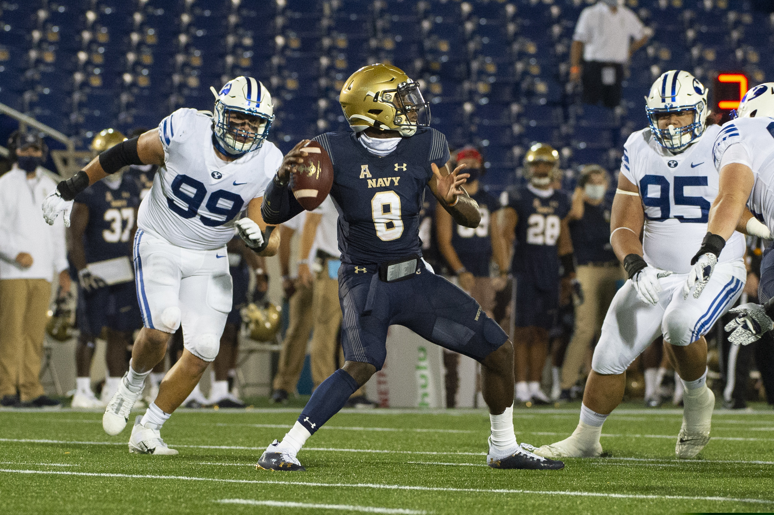 Navy quarterback Dalen Morris (8) looks to throw as BYU defensive lineman Zac Dawe (99) rushes in during the first half of an NCAA college football game, Monday, Sept. 7, 2020, in Annapolis, Md. (AP Photo/Tommy Gilligan)
