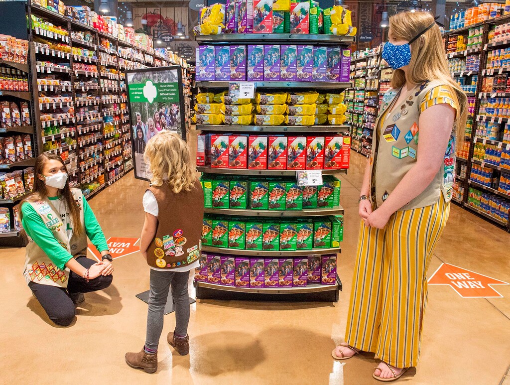 (Rick Egan  |  Tribune file photo) Girl Scouts Relena, 16, Ruth, 17, and Lillia, 8, at a Harmons grocery store, Friday, May 8, 2020. Harmons is now selling Girl Scout cookies in its stores to help complete sales of the cookies to fund Girl Scout activities during the coronavirus. More than 30 Girl Scout chapters across the country received PPP loans, the Treasury said.
