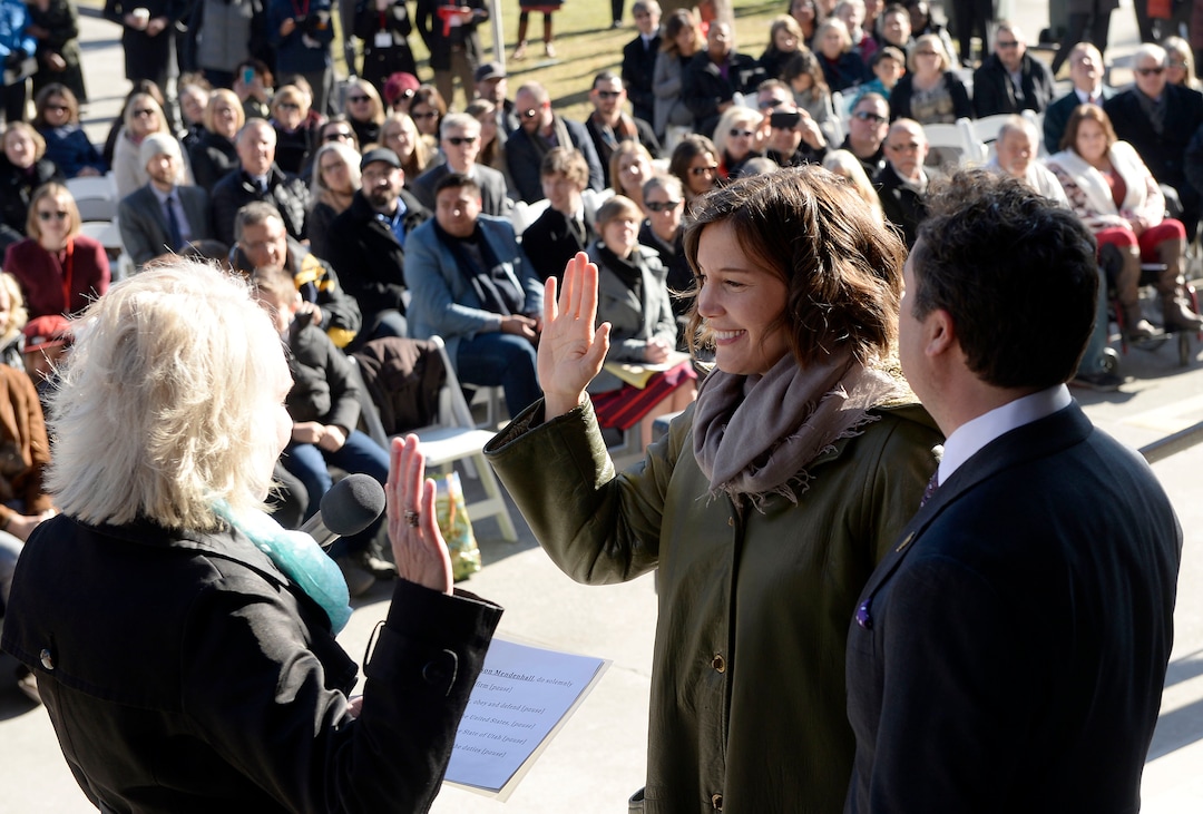 (Al Hartmann  |  The Salt Lake Tribune) 	City Recorder Cindi Mansell, left, administers oath of office to re-elected City Council Member Erin Robinson Mendenhall in ceremony outside the City-County Building Tuesday Jan. 2.  Her husband Kyle LaMalfa, right. 