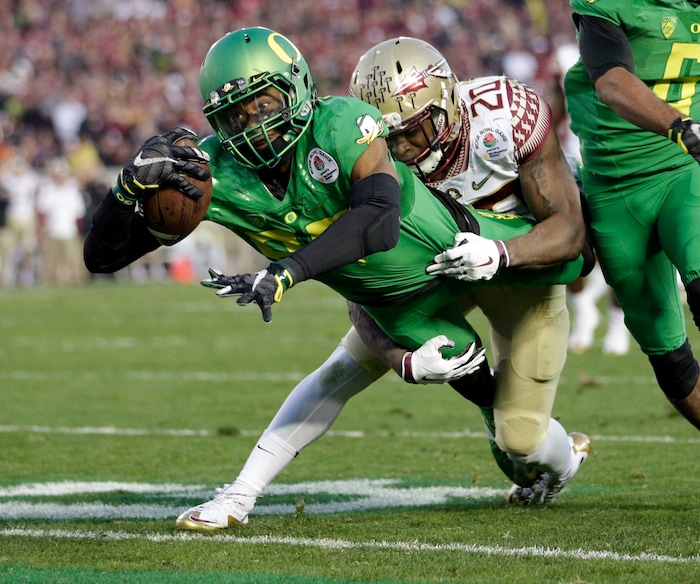 Oregon wide receiver Darren Carrington, front, scores under pressure by Florida State defensive back Trey Marshall during the second half of the Rose Bowl NCAA college football playoff semifinal, Thursday, Jan. 1, 2015, in Pasadena, Calif. (AP Photo/Jae C. Hong)