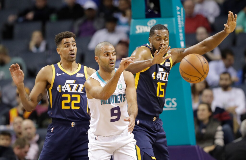 Charlotte Hornets' Tony Parker (9) passes the ball as Utah Jazz's Thabo Sefolosha (22) and Derrick Favors (15) defend during the first half of an NBA basketball game in Charlotte, N.C., Friday, Nov. 30, 2018. (AP Photo/Chuck Burton)