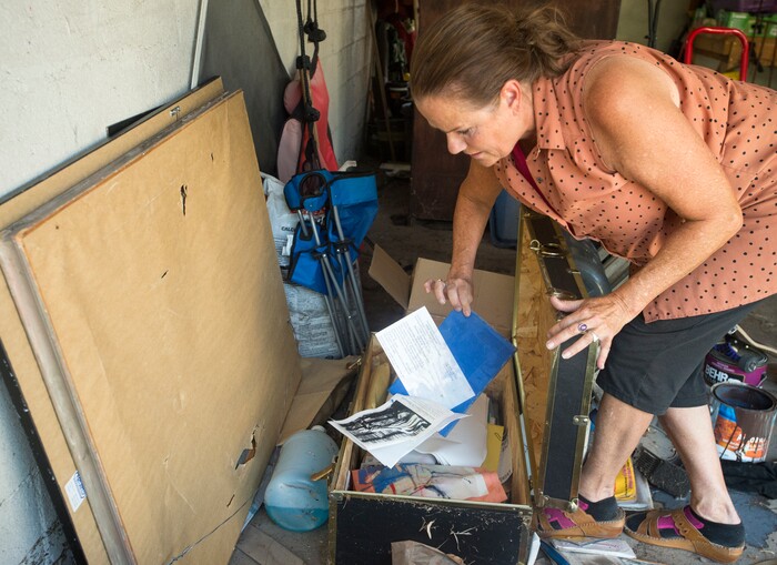 (Rick Egan  |  The Salt Lake Tribune)  Emmy Thomson sorts through photos and memorabilia that was destroyed in a hope chest, when water flooded her garage, at her home on Lincoln Street. Tuesday, August 1, 2017.