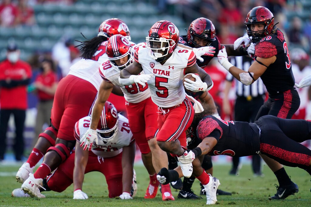 (Ashley Landis | AP) Utah running back TJ Pledger (5) is tripped up by San Diego State linebacker Michael Shawcroft (46) during the first half of an NCAA college football game Saturday, Sept. 18, 2021, in Carson, Calif.