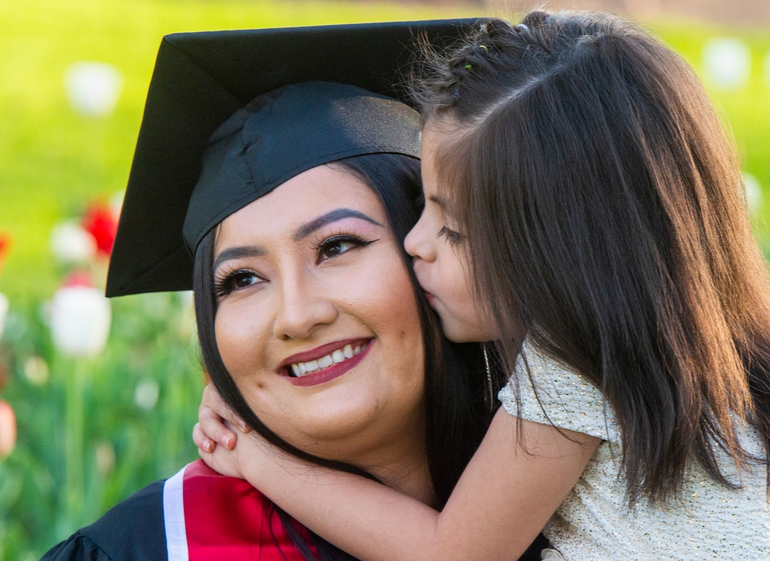 (Rick Egan  |  The Salt Lake Tribune)    Victoria Gamarra gets a kiss from her 5-year-old daughter Meilah Toro, as she poses for a graduation photo at Presidents Circle at the University of Utah, Thursday April 30, 2020