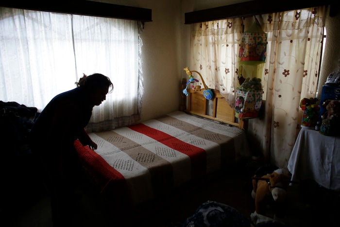In this Aug. 23, 2017 photo, Juana Pedraza makes the bed in the room her daughter Jessica shared with her 1-year-old son in the family's home in Villa Cuauhtemoc, Mexico state. Pedraza identified her 29-year-old daughter's body at the morgue. She had been shot in the head and decapitated, and the skin had been flayed from her skull. "I can't understand why," Pedraza said. "Why so much fury? Why so much hate?" (AP Photo/Rebecca Blackwell)