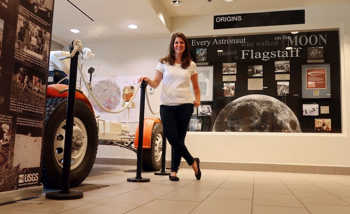 (Felicia Fonseca | AP) In this June 25, 2019 photo, Lauren Edgar, a research geologist for the U.S. Geological Survey's Astrogeology Science Center in Flagstaff, Ariz., poses in front of a prototype of a lunar rover.