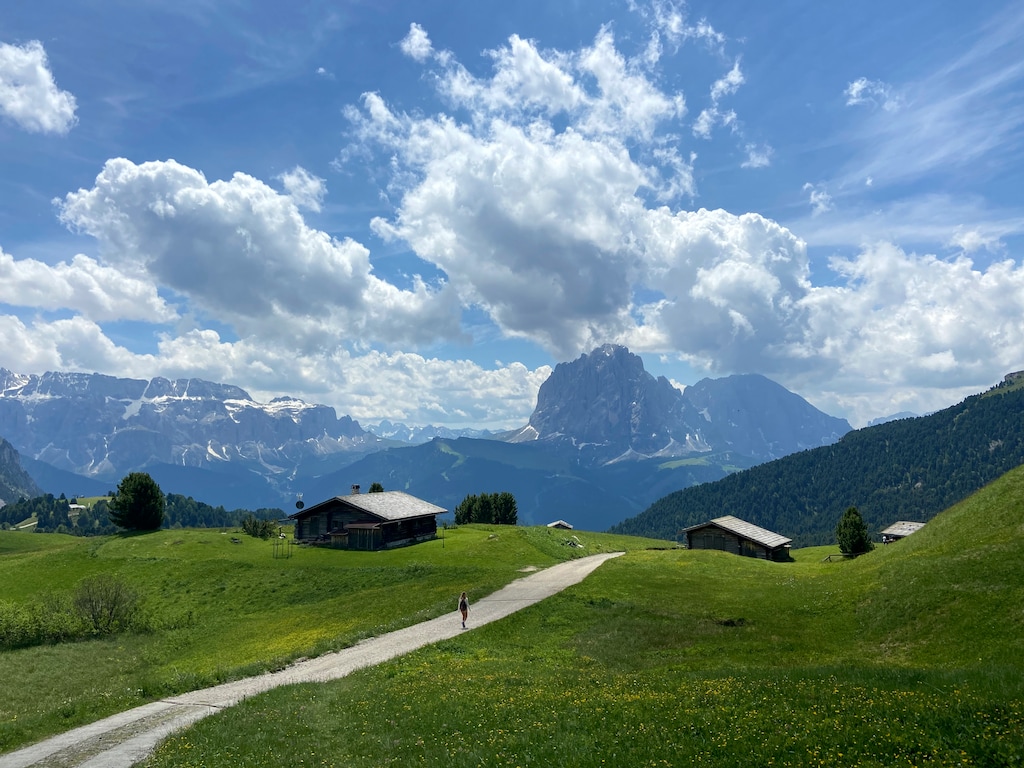 (Matthias Schrader | AP) A hiker makes her way in front of the 'Langkofel' Dolomites mountain near Ortisei val Gardena, South Tyrol, Italy in 2021.