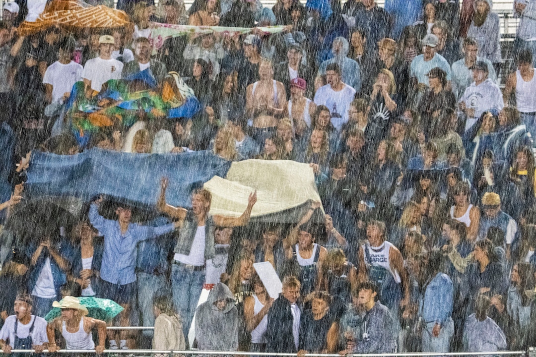 (Rick Egan | The Salt Lake Tribune)  Corner Canyon fans brave the lashing rain, as they return to the stadium after a 40 minute rain delay, as the Corner Canyon Chargers defeated the East Leopards, on Saturday, Aug. 21, 2021.