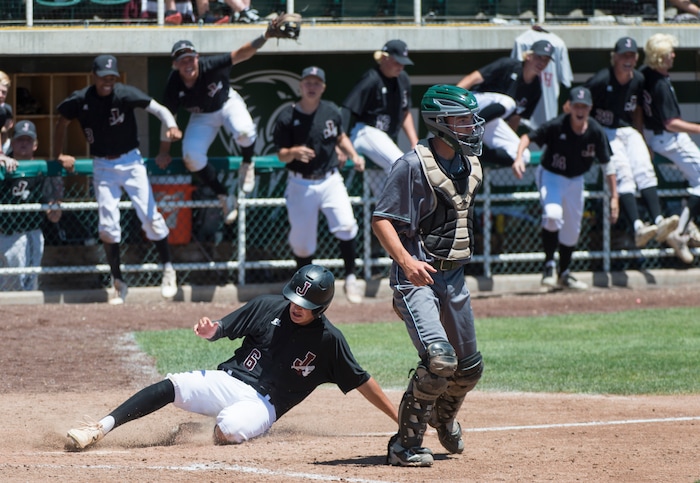 (Rick Egan  |  The Salt Lake Tribune)   Jordan High starts their celebration as Ricky Medina scores the 11th run of the game, as Jordan defeats Olympus their 11-1, for the 5A state baseball championship, at UVU in Orem, Friday, May 25, 2018.