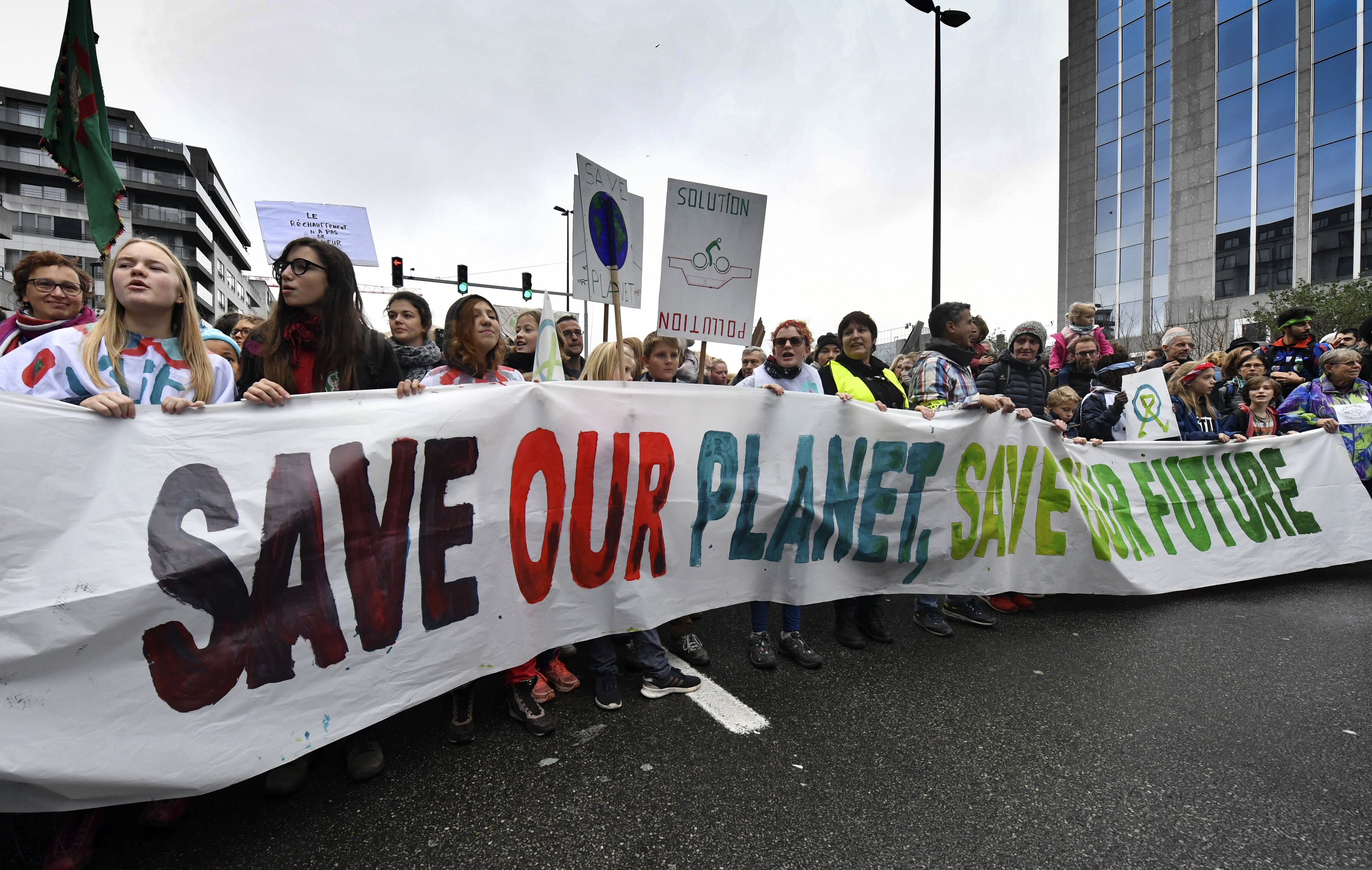 Demonstrators hold a banner which reads 'save our planet, save our future' during a 'Claim the Climate' march in Brussels, Sunday, Dec. 2, 2018. The climate change conference, COP24, will take place in Poland from Dec. 2-14. (AP Photo/Geert Vanden Wijngaert)