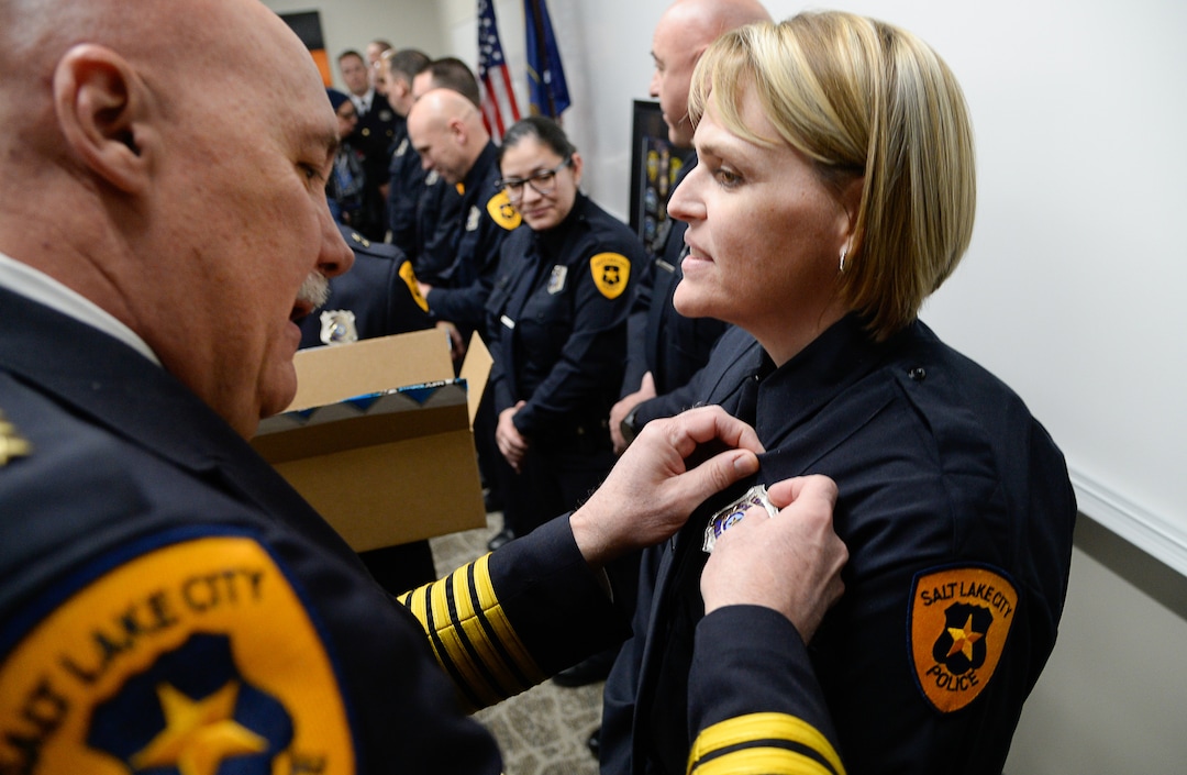 (Francisco Kjolseth  |  The Salt Lake Tribune)  Salt Lake City Police Chief Mike Brown pins a new badge on patrol officer Sarah Hill of the airport police force during a ceremony to retire their patch and badge and be subsumed into the Salt Lake City Police Department on Tuesday, Feb. 26, 2019. 