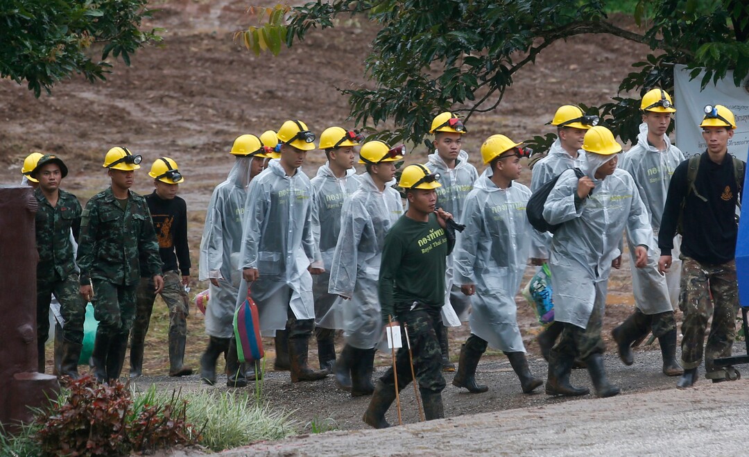 Rescuers walk toward the entrance to a cave complex where five were still trapped, in Mae Sai, Chiang Rai province, northern Thailand Tuesday, July 10, 2018. The eight boys were rescued from the flooded cave. (AP Photo/Sakchai Lalit)