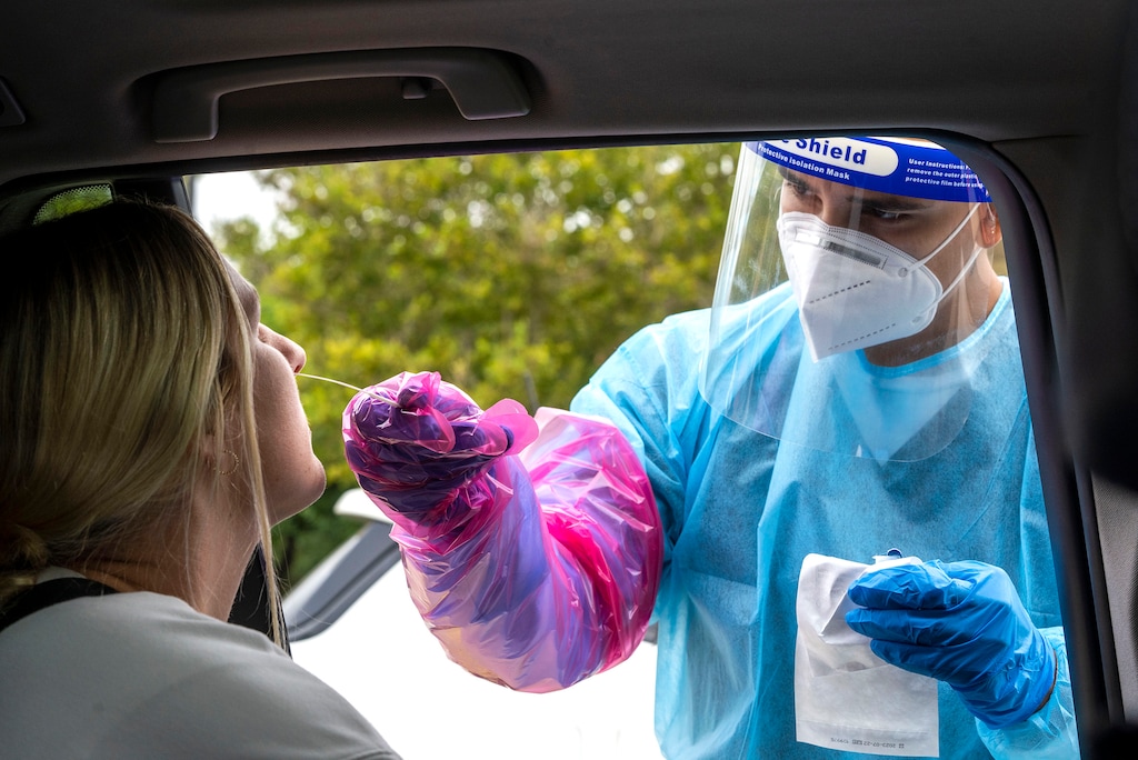 (Rick Egan | The Salt Lake Tribune) A health worker tests Morgan Munfod for COVID-19 at the Utah Department of Health parking lot, on Wednesday, Sept. 1, 2021.