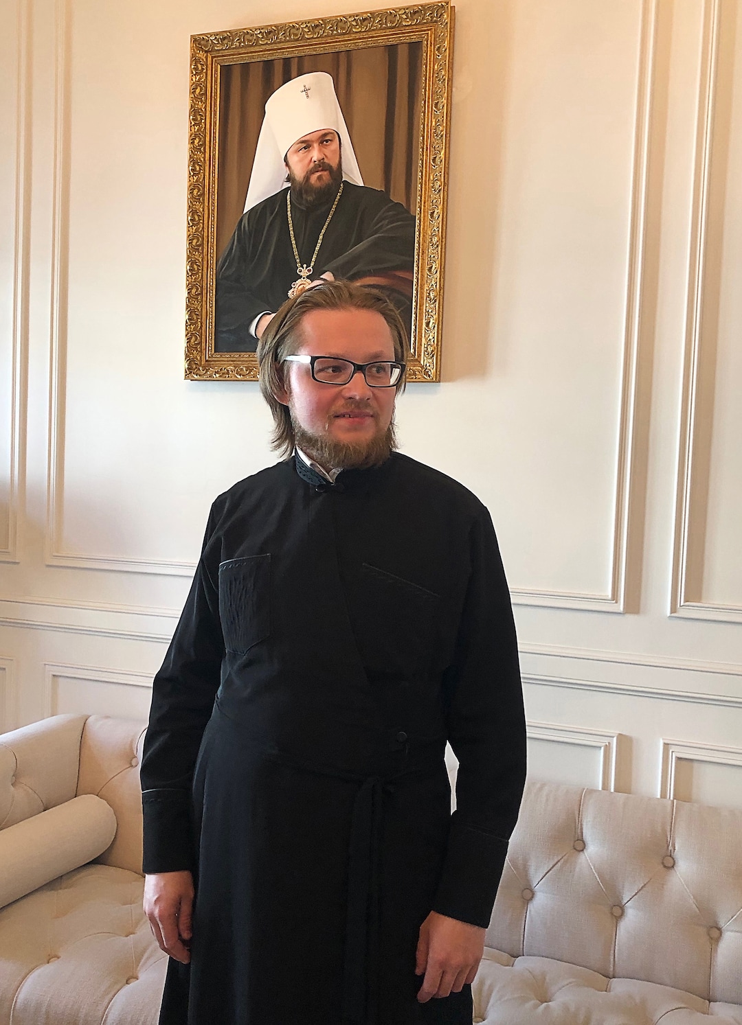 (Michael Stack  |   Special to The Salt Lake Tribune) Father Dmitry Serov, deputy director of the international department at Sts. Cyril and Methodius Theological Institute of Postgraduate Studies in Moscow, stands in front of a portrait of the Metropolitan Hilarion of Volokolamsk.