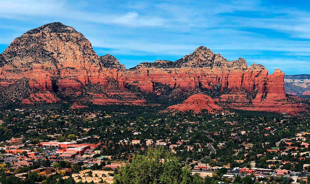 This 2018 photo shows the town of Sedona, Ariz., seen from the Airport Mesa Loop Trail. From left to right are Thunder Mountain, Sugar Loaf and Coffee Pot Rock. The sleepy Arizona town of Sedona has long been a refuge for hikers, romantics and soul searchers. There’s picturesque beauty in its earth-toned buildings and also in the glowing red rocks that surround town. And many visitors come looking for something besides this beauty: the so-called vortex where some say the earth’s energy crackles and creates sensations of healing and spiritual awakening. (AP Photo/Joseph Gedeon)