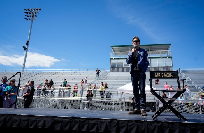 (Bethany Baker | The Salt Lake Tribune) Kevin Bacon speaks on stage during a charity event to commemorate the 40th anniversary of the movie "Footloose" on the football field of Payson High School in Payson on Saturday, April 20, 2024.