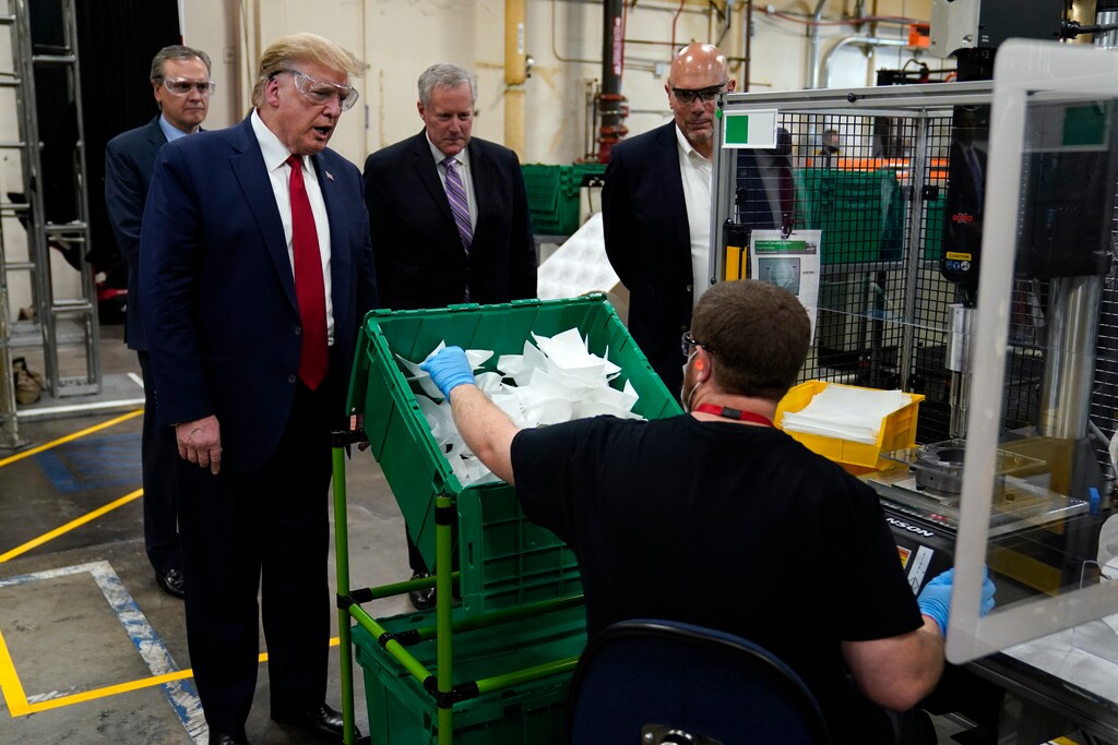 President Donald Trump participates in a tour of a Honeywell International plant that manufactures personal protective equipment, Tuesday, May 5, 2020, in Phoenix, with Tony Stallings, vice president of Integrated Supply Chain at Honeywell, right and White House chief of staff Mark Meadows. (AP Photo/Evan Vucci)