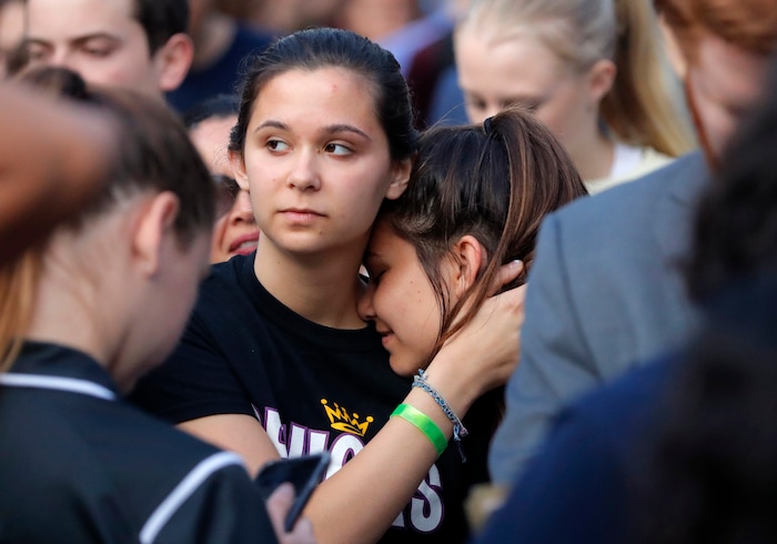 Julia Salomone, 18, left, and her sister Lindsey Salomone, 15, student survivors from Marjory Stoneman Douglas High School hug as they march to the state capitol to challenge lawmakers on gun control reform, in Tallahassee, Fla., Wednesday, Feb. 21, 2018.    The students split into several groups to talk with lawmakers and other state leaders about gun control, the legislative process, and mental health issues. (AP Photo/Gerald Herbert)