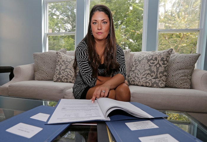 Former Word of Faith Fellowship church member Rachael Bryant poses for a photo with her tax records at her home in Charlotte, N.C., Tuesday, Sept. 19, 2017. She and 10 other members of the evangelical North Carolina-based church say their leader, Jane Whaley, coerced congregants into filing false unemployment claims after the faltering economy threatened weekly tithes from church-affiliated companies. (AP Photo/Chuck Burton)