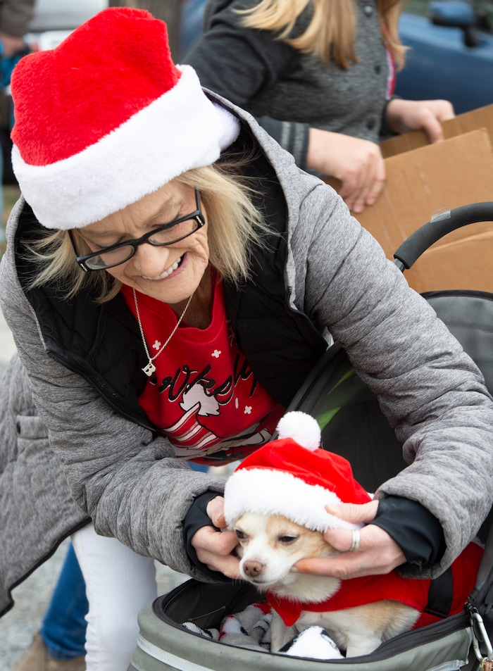 (Rick Egan  |  The Salt Lake Tribune)    Barbara Dawkins dresses her dog Jojo n a Santa suit, at the Street Dawg Crew Christmas outreach at Liberty Park Sunday.  The Street Dawg Crew supports the homeless and their pets every Sunday at Pioneer Park.  For today's Christmas Outreach, the Street Dawg Crew passed out food and gift bags for humans and animals, and also offered a photo opportunity with Santa. Sunday, Dec. 22, 2019.