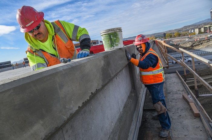 (Francisco Kjolseth  |  The Salt Lake Tribune)  Miguel Jimenez, left, and Manuel Robles do patchwork as UDOT completes the first stage of the new Triumph Blvd bridge in Lehi, opening East to West traffic on Thursday, Nov. 1, 2018, as part of the I-15 Technology Corridor Project.
