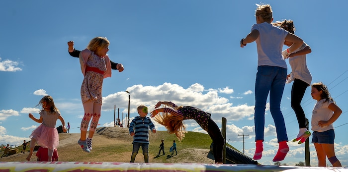 Leah Hogsten | The Salt Lake Tribune Shoeless kids jump on the giant jump pad during the 2018 Fall Festival at Cross E Ranch in Salt Lake City, Thursday Oct. 18, 2018.