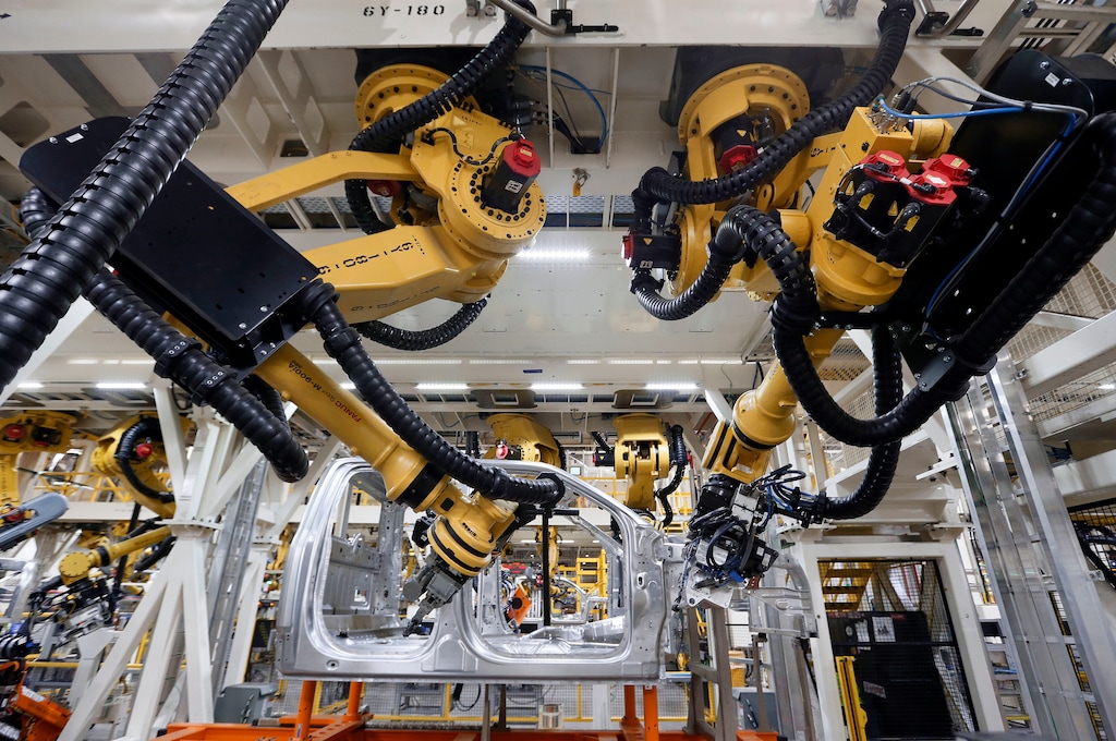 FILE - In this Nov. 11, 2014, file photo, robots install rivets on a 2015 Ford F-150 truck at the Dearborn Truck Plant in Dearborn, Mich. Cheaper, better robots will replace human workers in the world's factories at a faster pace over the next decade, pushing manufacturing labor costs down 16 percent, a report from the Boston Consulting Group said Tuesday, Feb. 10, 2015. (AP Photo/Paul Sancya, File)