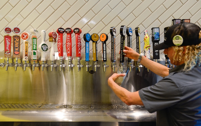 (Francisco Kjolseth  |  The Salt Lake Tribune)  Joshua Britten pours a pint of Park City Brewerey's special beer produced for the new Silver Mine Taproom inside the new Whole Foods Market at Kimball Junction where 24-beers are on tap.