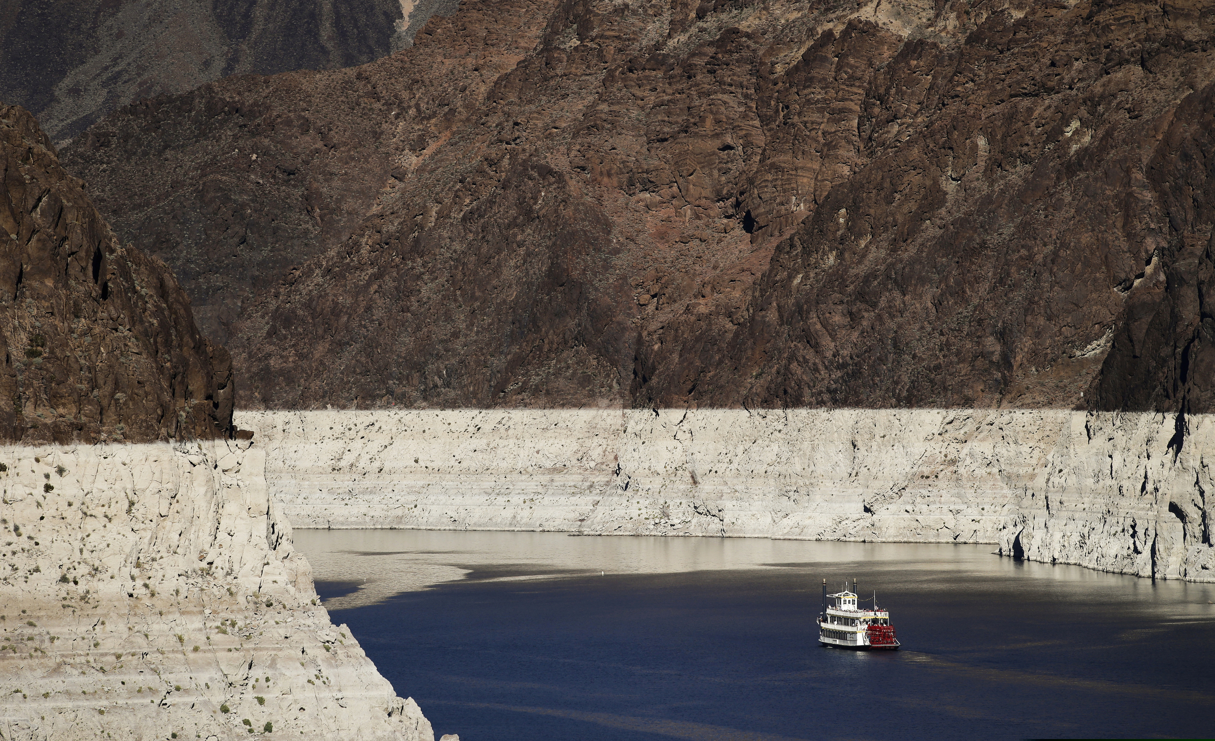 (Jae C. Hong | AP file photo) A riverboat glides through a low-water Lake Mead on the Colorado River at Hoover Dam near Boulder City, Nev., in October 2015. Arizona and Nevada will face their first-ever cuts in Colorado River water next year, but the changes aren’t expected to be overly burdensome for either state.