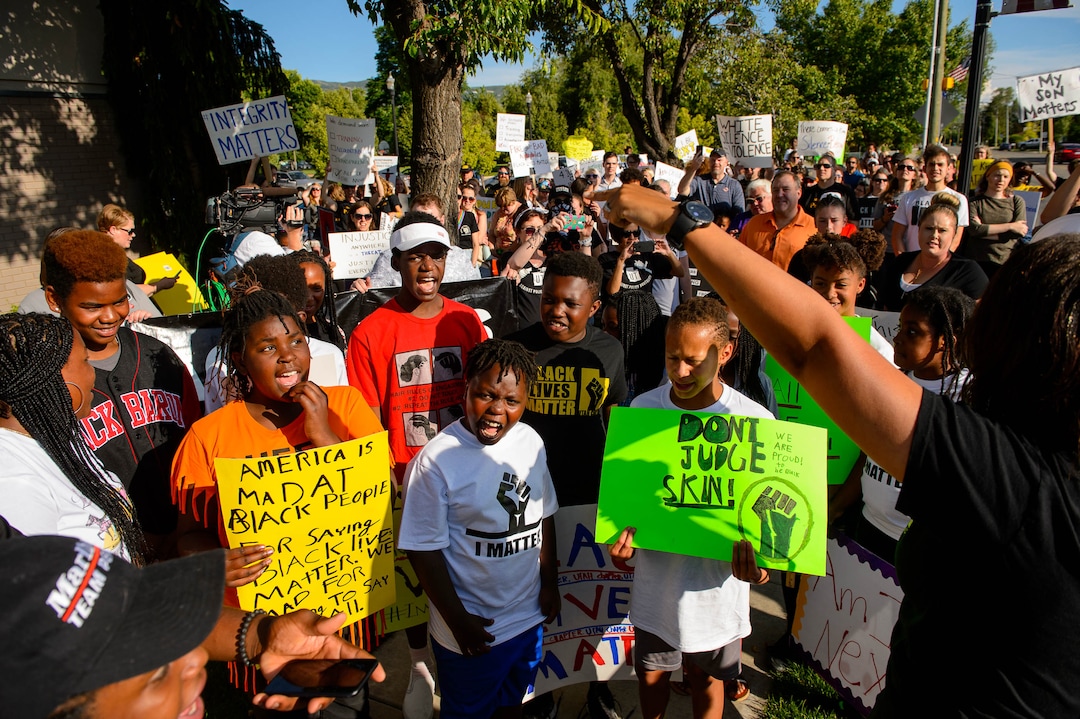(Trent Nelson  |  The Salt Lake Tribune)Lex Scott leads chants at a protest organized by Black Lives Matter and other groups at the Woods Cross Police Department on Friday June 14, 2019. The rally was to show support for DJ Hrubes, a 10-year-old black child who was held at gunpoint by a police officer last week while playing in his grandmother's front yard.