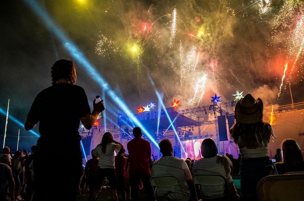 (Isaac Hale | Special to The Tribune) Attendees dance while fireworks burst over LaVell Edwards Stadium in Provo during Stadium of Fire in 2021. 