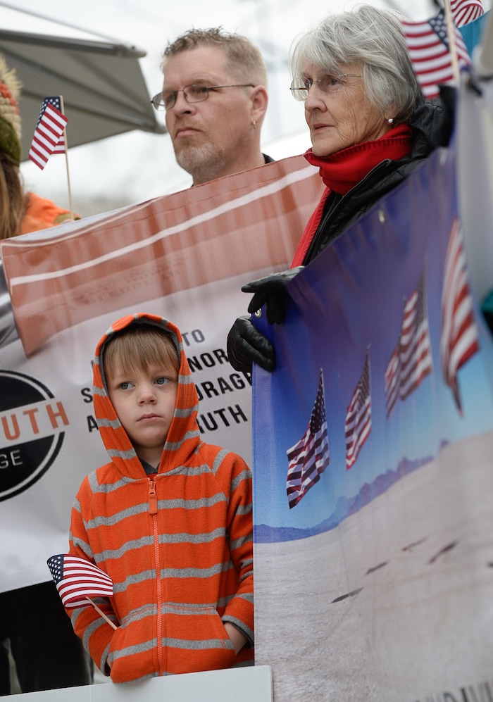 (Francisco Kjolseth  |  The Salt Lake Tribune)  Cameron Wallace, 5, Ken Whitaker and Thea Brannon, clockwise from bottom, join a group of Utahns to rally at the Wallace Bennett Federal Building in Salt Lake to tell personal stories of how they might be impacted by the tax reform plans currently on the table in Congress.