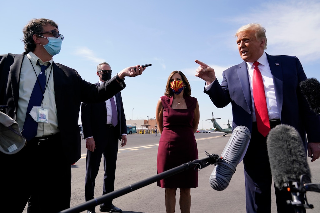 (Alex Brandon | AP)  President Donald Trump talks to reporters at Phoenix Sky Harbor International Airport, Monday, Oct. 19, 2020, in Phoenix. Second from right is Sen. Martha McSally, R-Ariz.