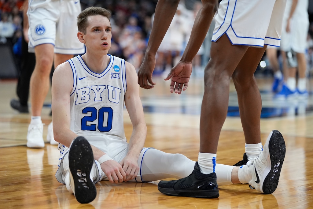 (Charlie Neibergall | AP) BYU guard Spencer Johnson (20) sits on the floor after being fouled in the first half of a first-round college basketball game against Duquesne in the NCAA Tournament, Thursday, March 21, 2024, in Omaha, Neb.