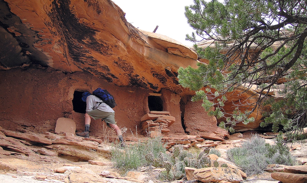 (Al Hartmann  |  The Salt Lake Tribune)  Backpacker explores an Anasazi ruin under a sandstone alcove in a canyon on Cedar Mesa in San Juan County.  The area is included for a proposed Bears Ears National Conservation Area.