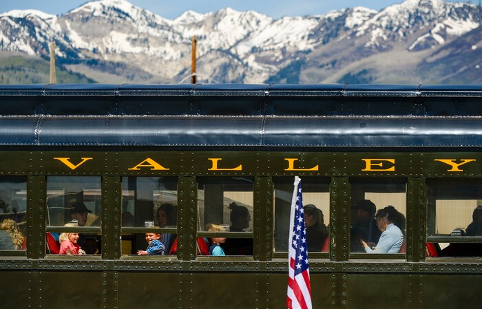 (Leah Hogsten  |  The Salt Lake Tribune) Passengers in a train car at the historic Heber Valley Railroad watch American flags waving in the wind to honor military, past and present, men and women who serve or have served in our Armed Forces in celebration of Heber City 2020 Memorial Day Drive By Tribute, May 25, 2020.