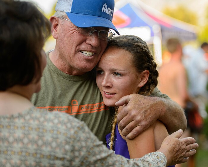 (Trent Nelson  |  The Salt Lake Tribune)  North Summit runner Sadie Sargent is embraced by her grandparents, Milt and Becky Sargent, after taking first in the Highland Invitational high school cross country meet Thursday August 17, 2017. Sargent is by far the fastest runner in Class 2A. She owns the 2A state record for fastest time at the state meet for a freshman, sophomore and junior, and she'll try to make it four for four later this year.
