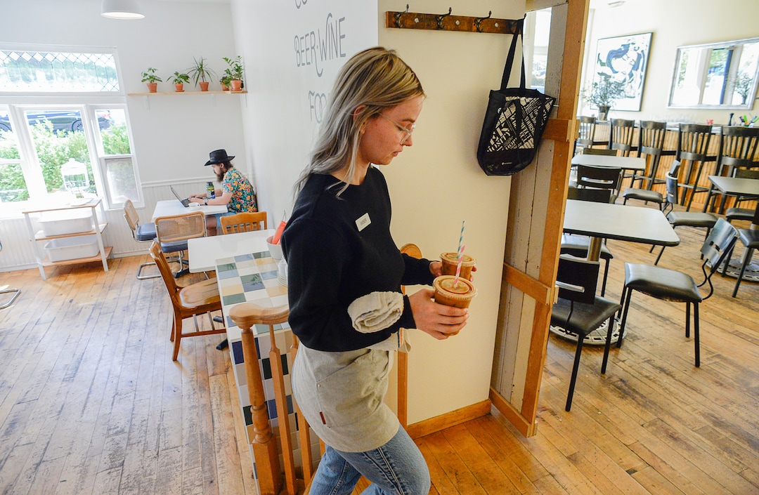 (Francisco Kjolseth  |  The Salt Lake Tribune)  Amber Dwyer delivers drinks from The Dayroom coffee shop through the adjacent Em's restaurant on her way to a large shared patio on the other side near the state capital.