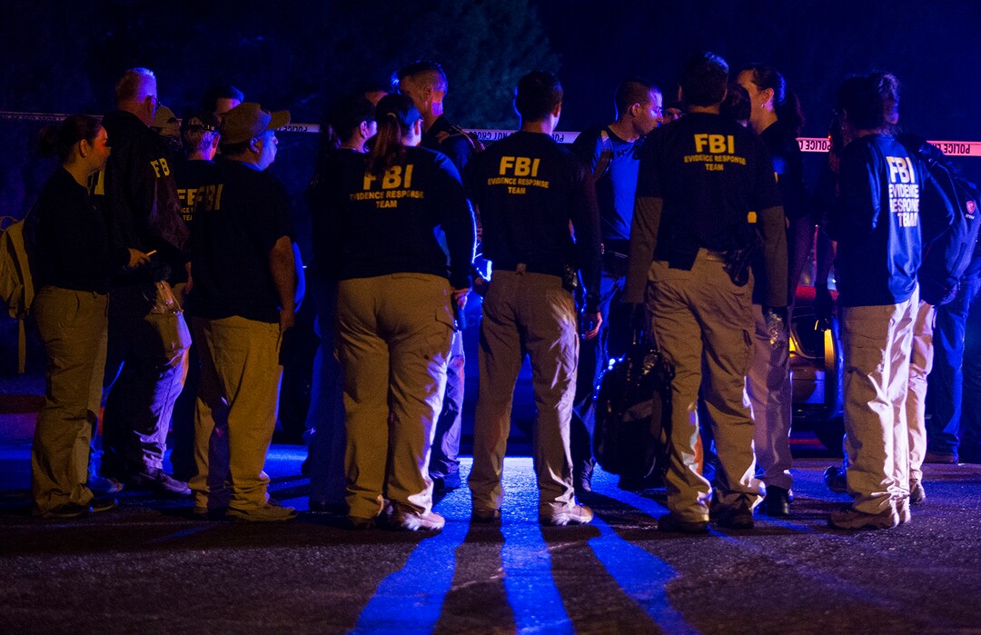 FBI agents meet at the scene of an explosion in Austin, Texas, Sunday, March 18, 2018. At least a few people were injured in another explosion in Texas' capital late Sunday, after three package bombs detonated this month in other parts of the city, killing two people and injuring two others. (Nick Wagner/Austin American-Statesman via AP)