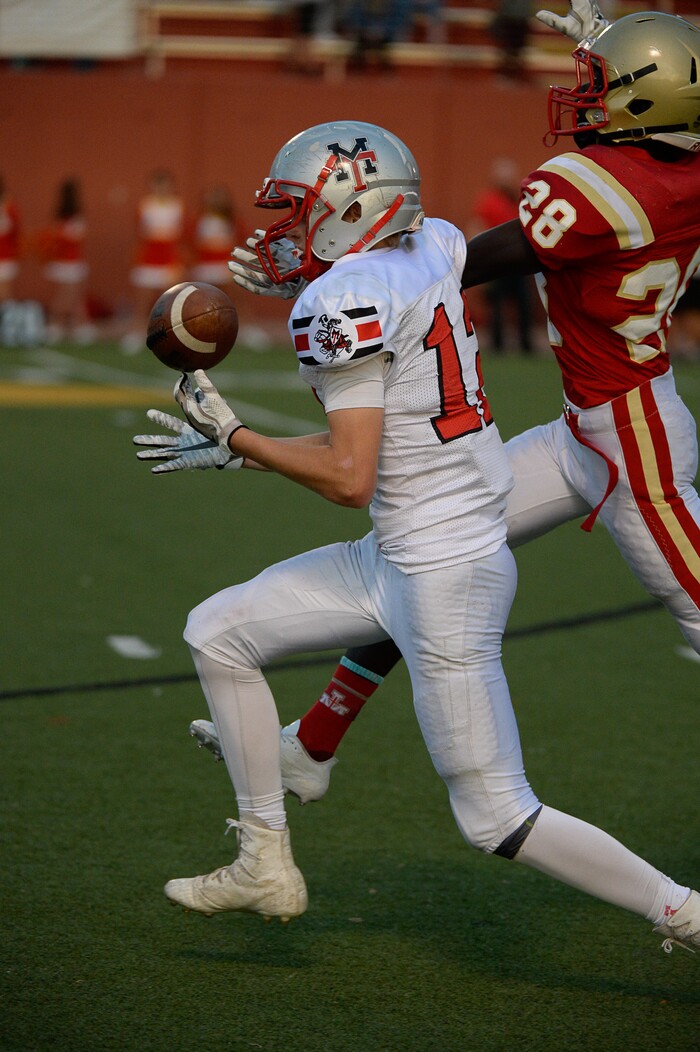 (Francisco Kjolseth  |  The Salt Lake Tribune)  Travis Thompson of Manti pulls in a long pass while pressured by  Fredrick Charles of Judge in the Class 3A football playoff game at Judge Memorial on Thursday, Oct. 19, 2017. 