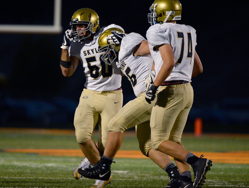 (Scott Sommerdorf   |  The Salt Lake Tribune)   
Skyline's Dax Lowe, center, celebrates with teammates after his interception against Brighton on Friday.