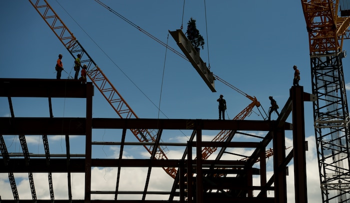 (Leah Hogsten  |  The Salt Lake Tribune) Iron Workers (not in order) Mike Herrera, Chance Bogue, Curtis Loya, Kevin Johnson, Jeff Wilber and Irving Benally with Local Union 27 position the last steel beam, topped with a tinsel decorated tree, during a "topping out" ceremony at the new Salt Lake City International terminal building, Wednesday, May 23, 2018. Such ceremonies can be traced to Scandinavian rites to place a tree atop a new building to appease the tree-dwelling spirits displaced during Construction.