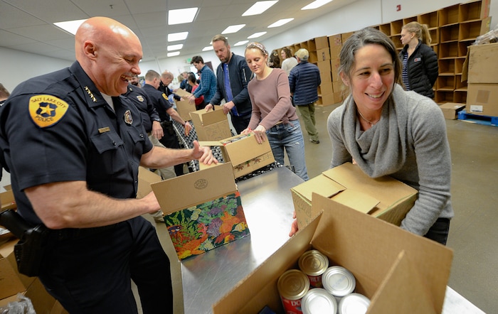 (Francisco Kjolseth  |  The Salt Lake Tribune) Police Chief Mike Brown and Director of the Salt Lake City Department of Public Utilities Laura Briefer help work the line assembling boxes of food as they join other officials and YouthCity Government students by volunteering at the Utah Food Bank to celebrate the 2020 Martin Luther King Jr. Day of Service on Monday, Jan. 20, 2020.