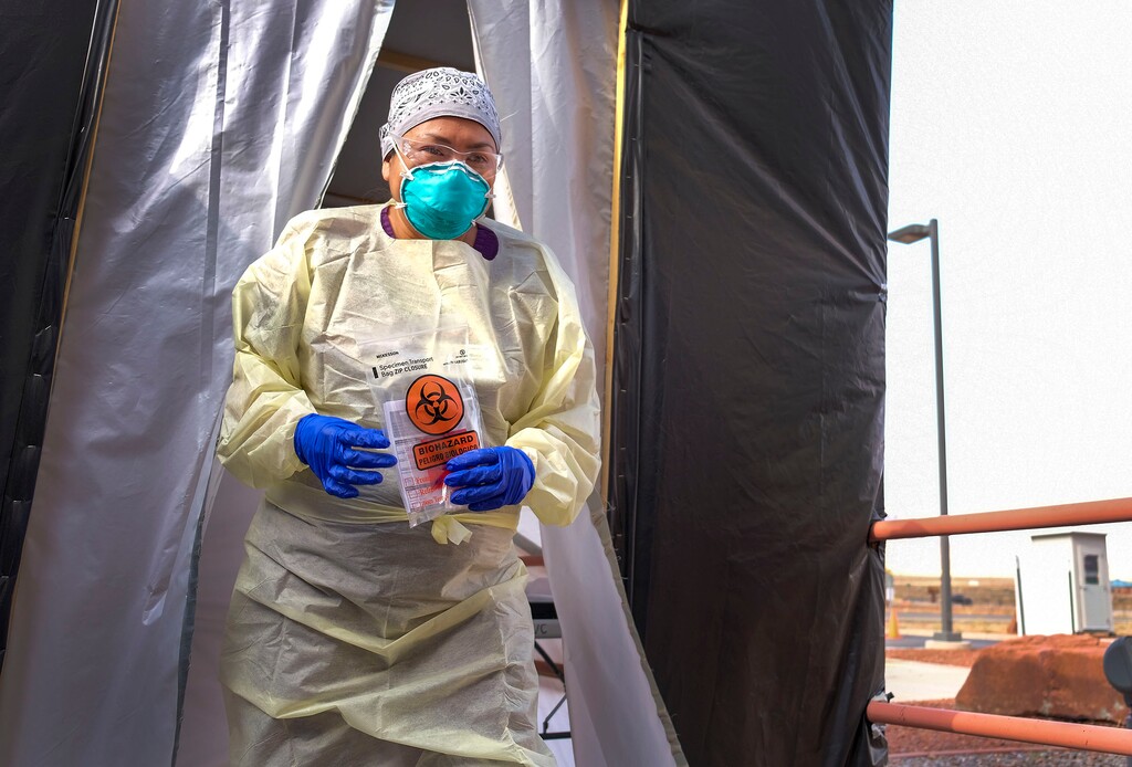(Leah Hogsten | Tribune file photo) Shelly Begay, a Diné medical assistant at Utah Navajo Health System’s Monument Valley Clinic, carries a patient’s coronavirus test kit out of the mobile triage unit for transport and testing on Aug., 24, 2020.